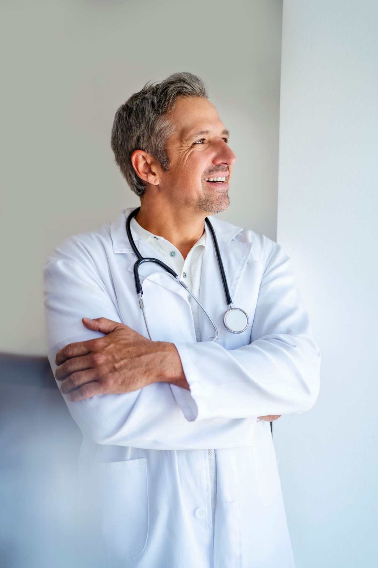 Smiling doctor with arms crossed looking away